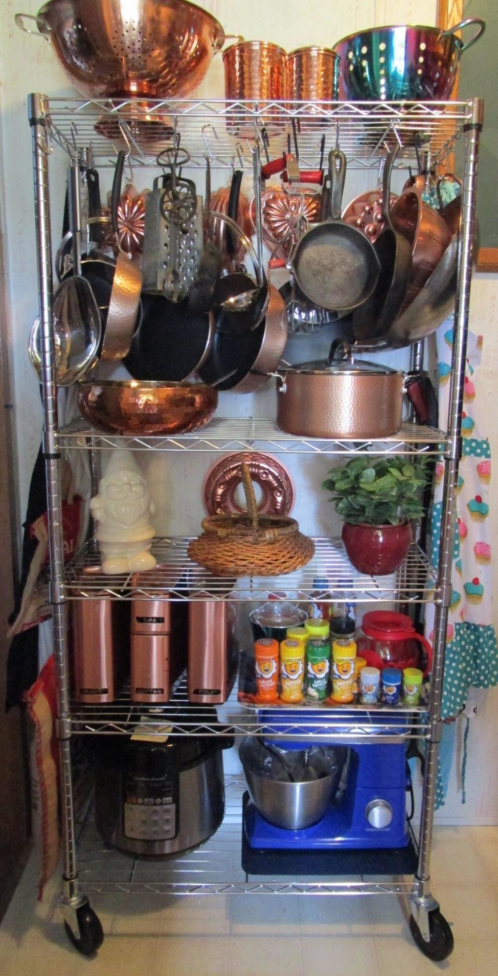 a reviewer photo of the silver rack with kitchen appliances and tools on every shelf