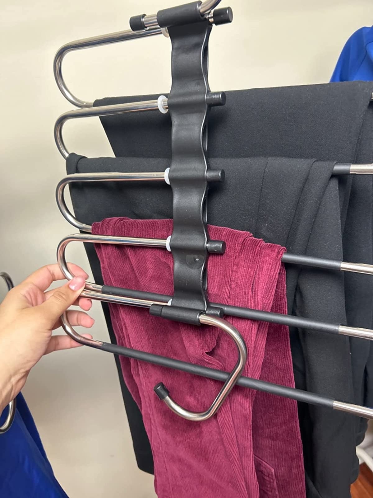 a reviewer photo showing several pairs of pants on the vertical hanger