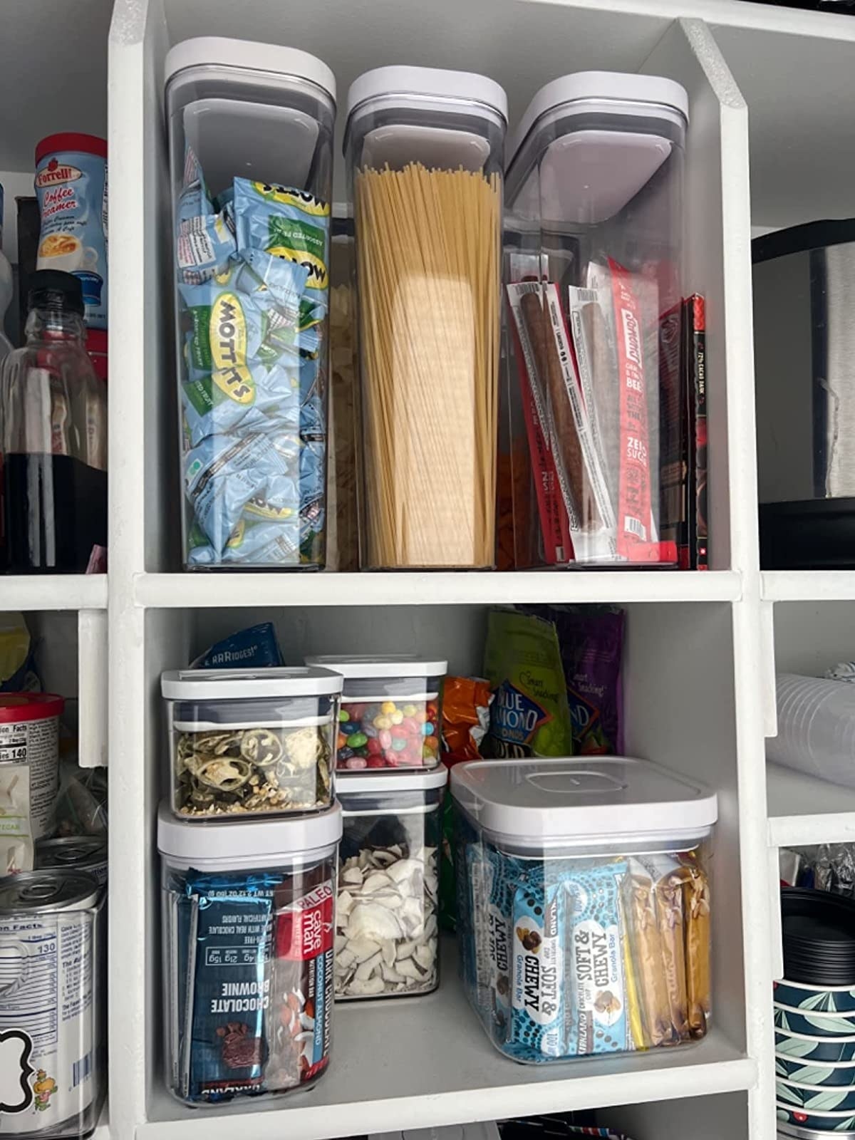 a reviewer photo of a pantry with many different sizes of airtight containers, filled with different kinds of food