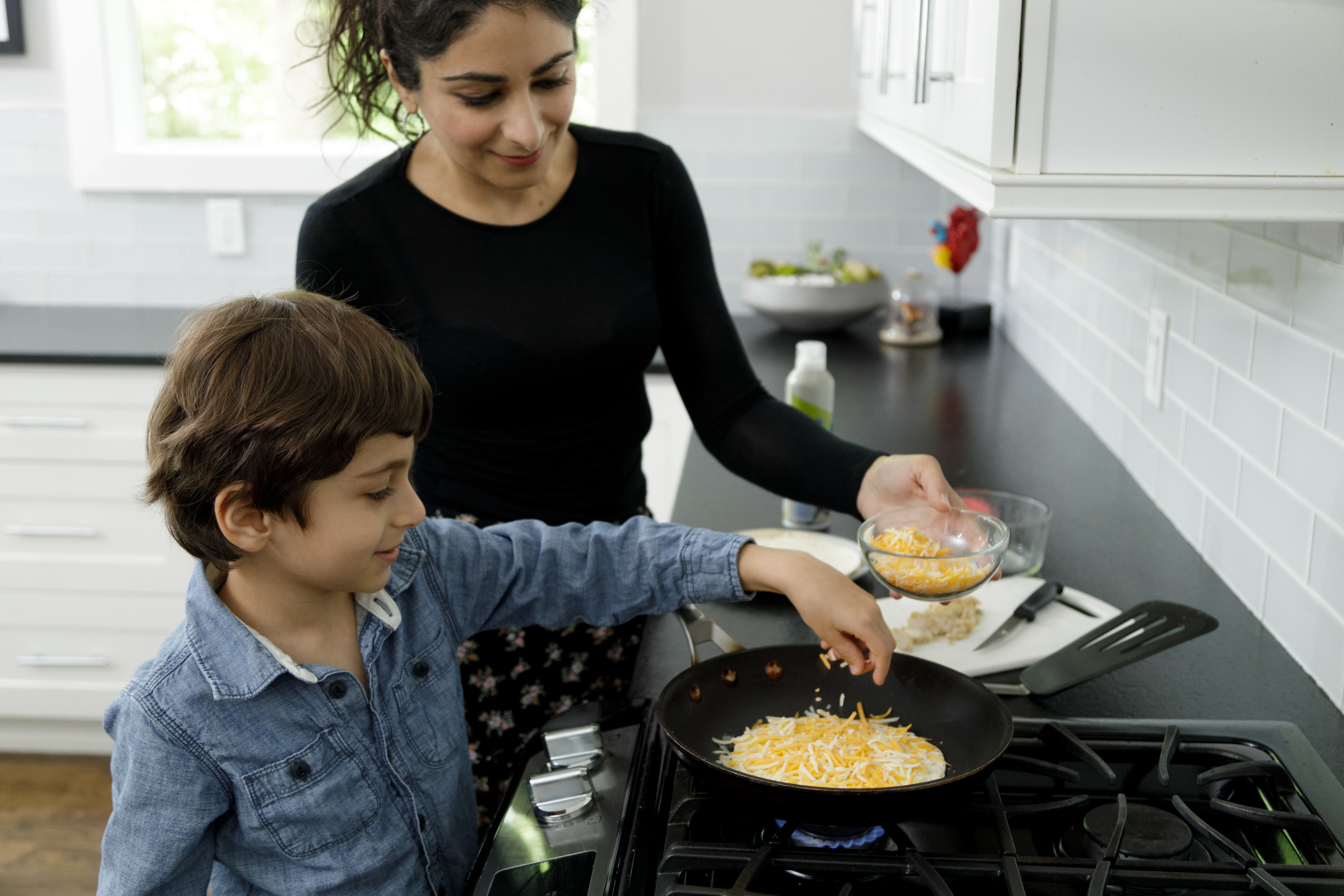 woman making quesadillas with her son