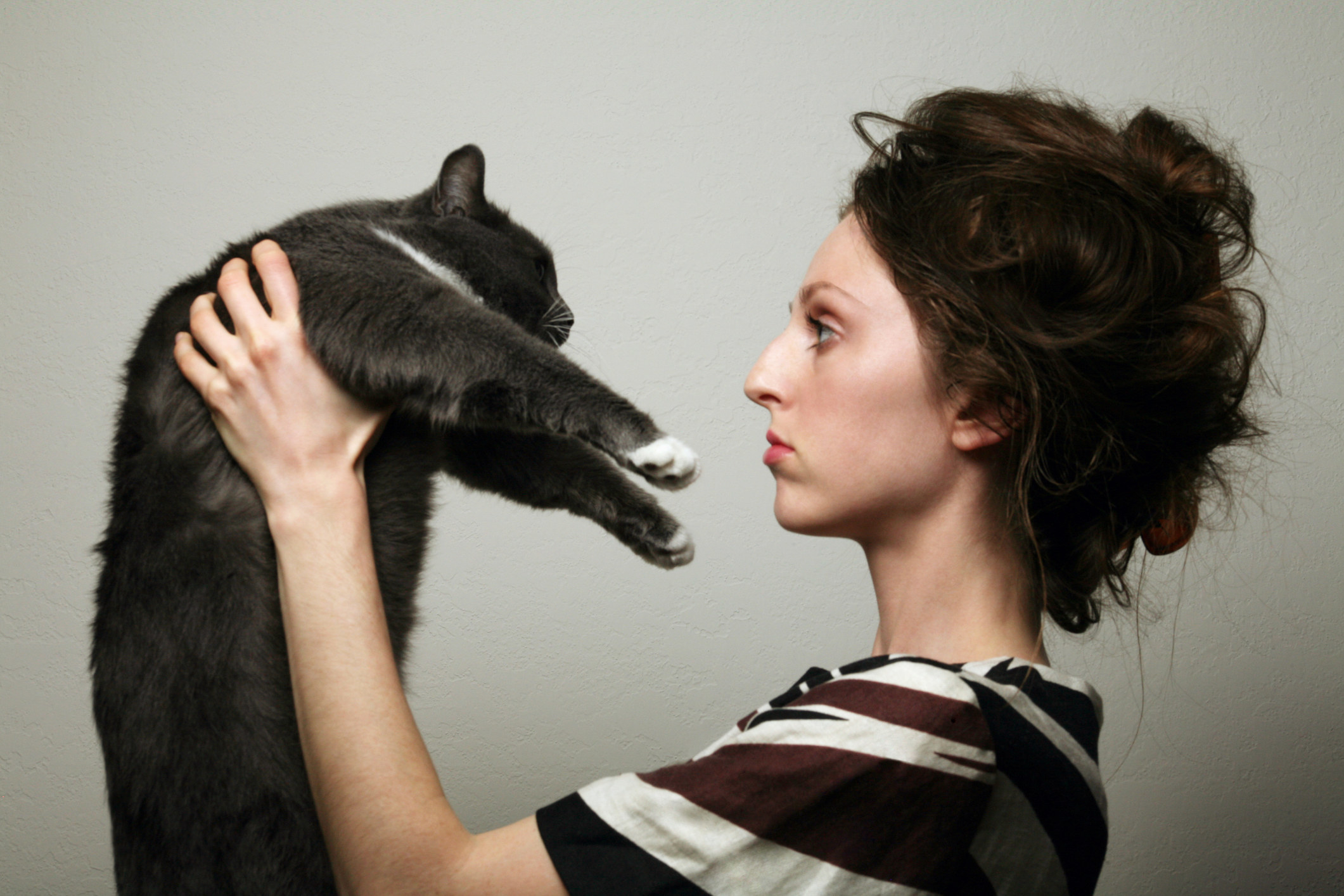 A woman holding a cat in front of her