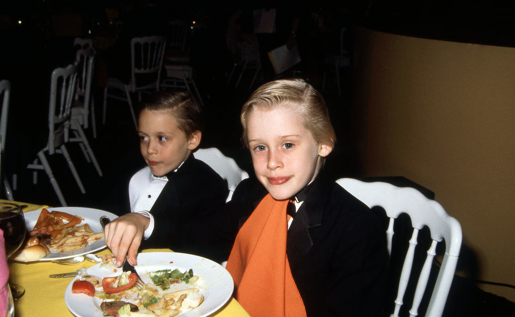 The brothers at a an event sitting at a dinner table
