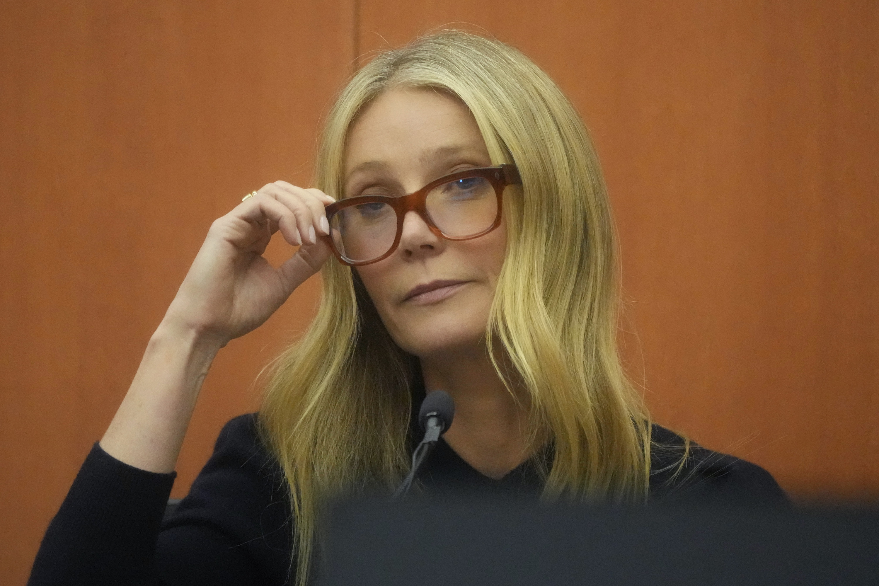 Gwyneth touching her glasses in court