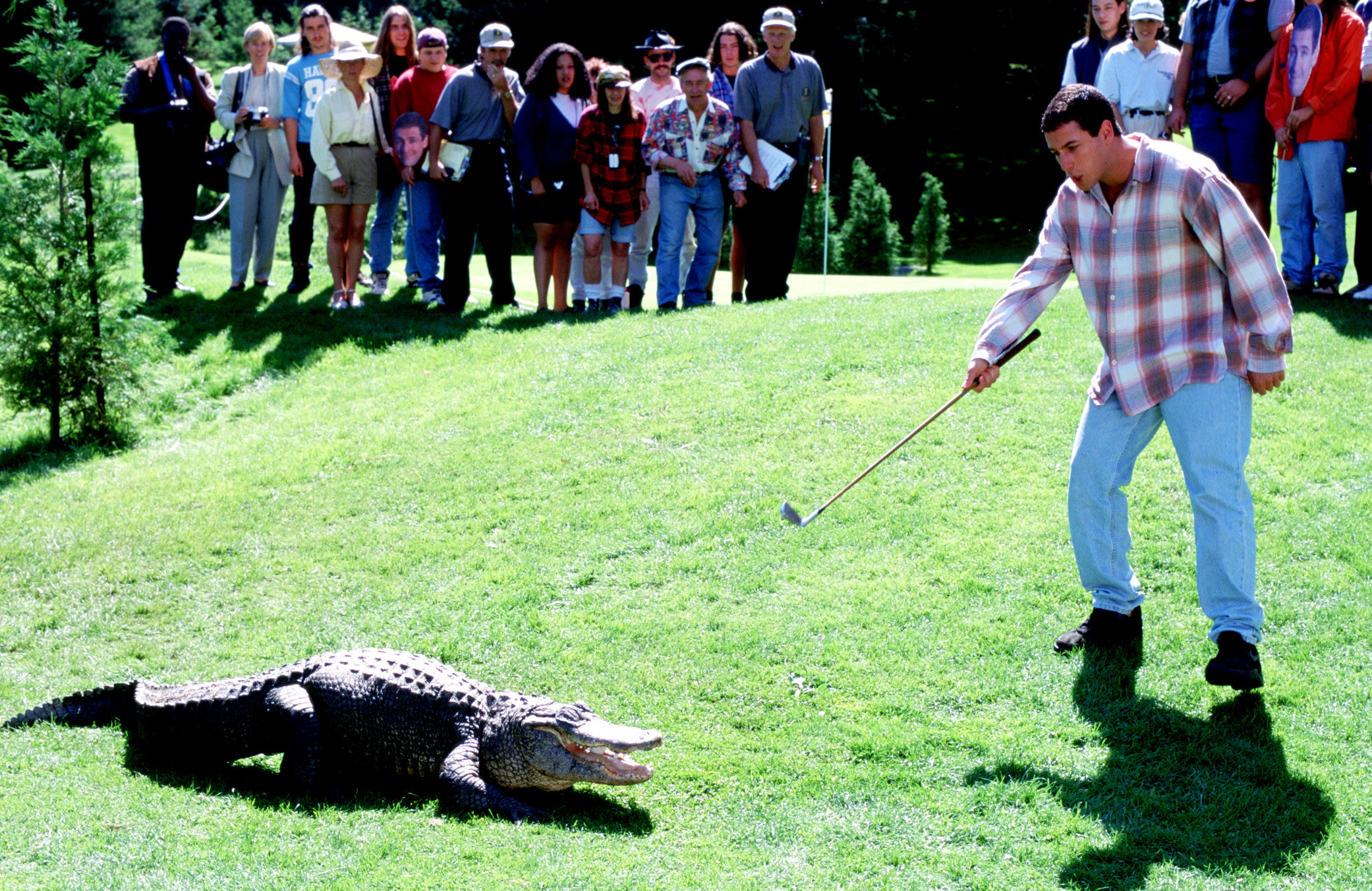Adam Sandler aims his golf club at an alligator