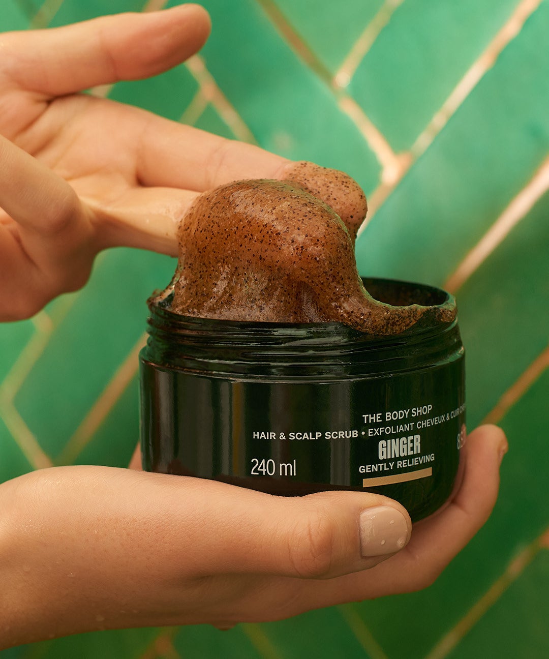 A person holding a tub of the scalp scrub