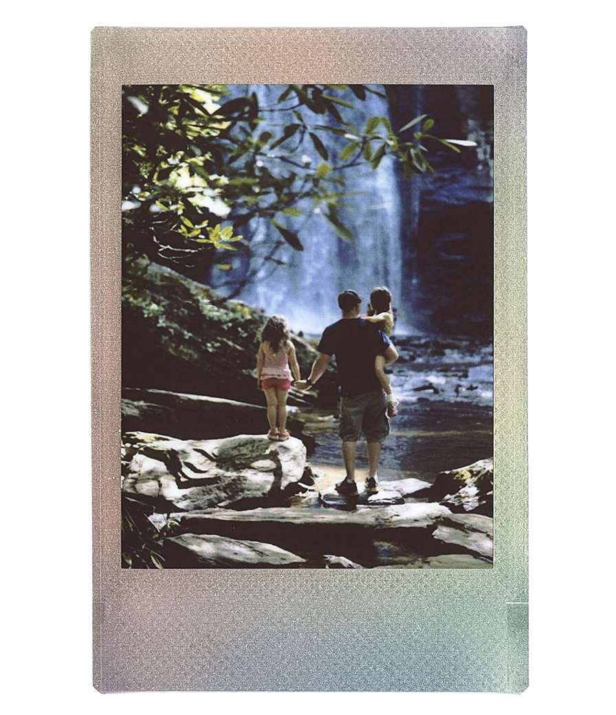 an instax mini picture of people walking beside a waterfall