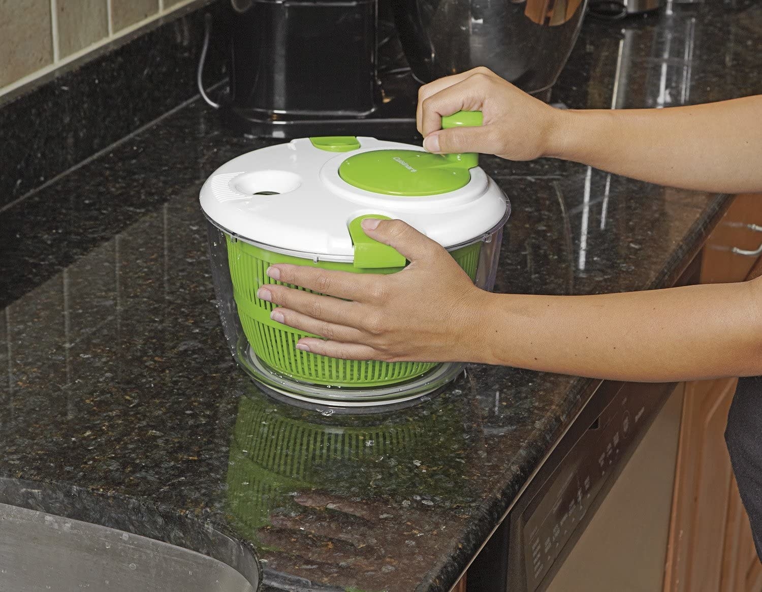 person using the handle on the salad spinner