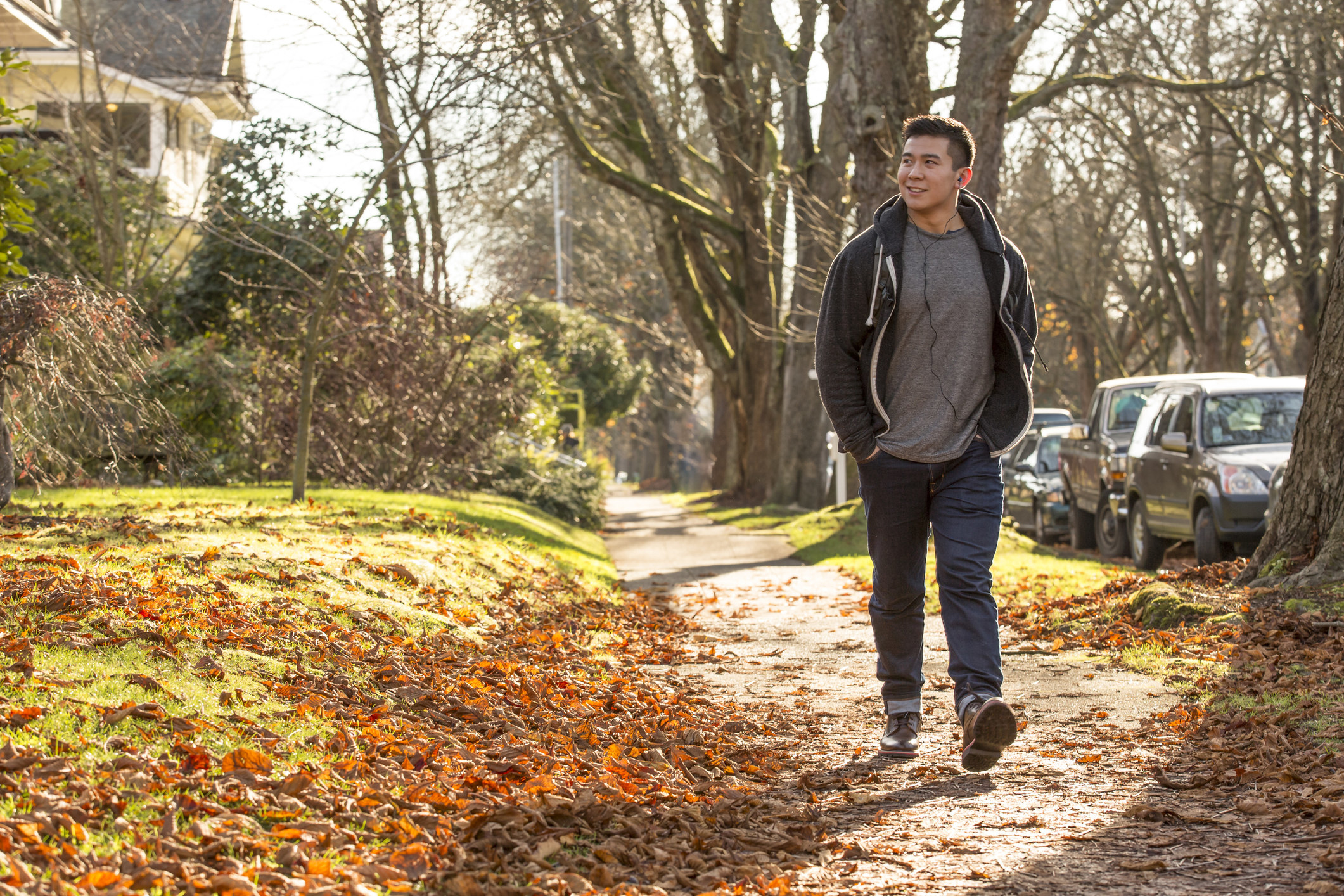 A man walking along a street on a fall day