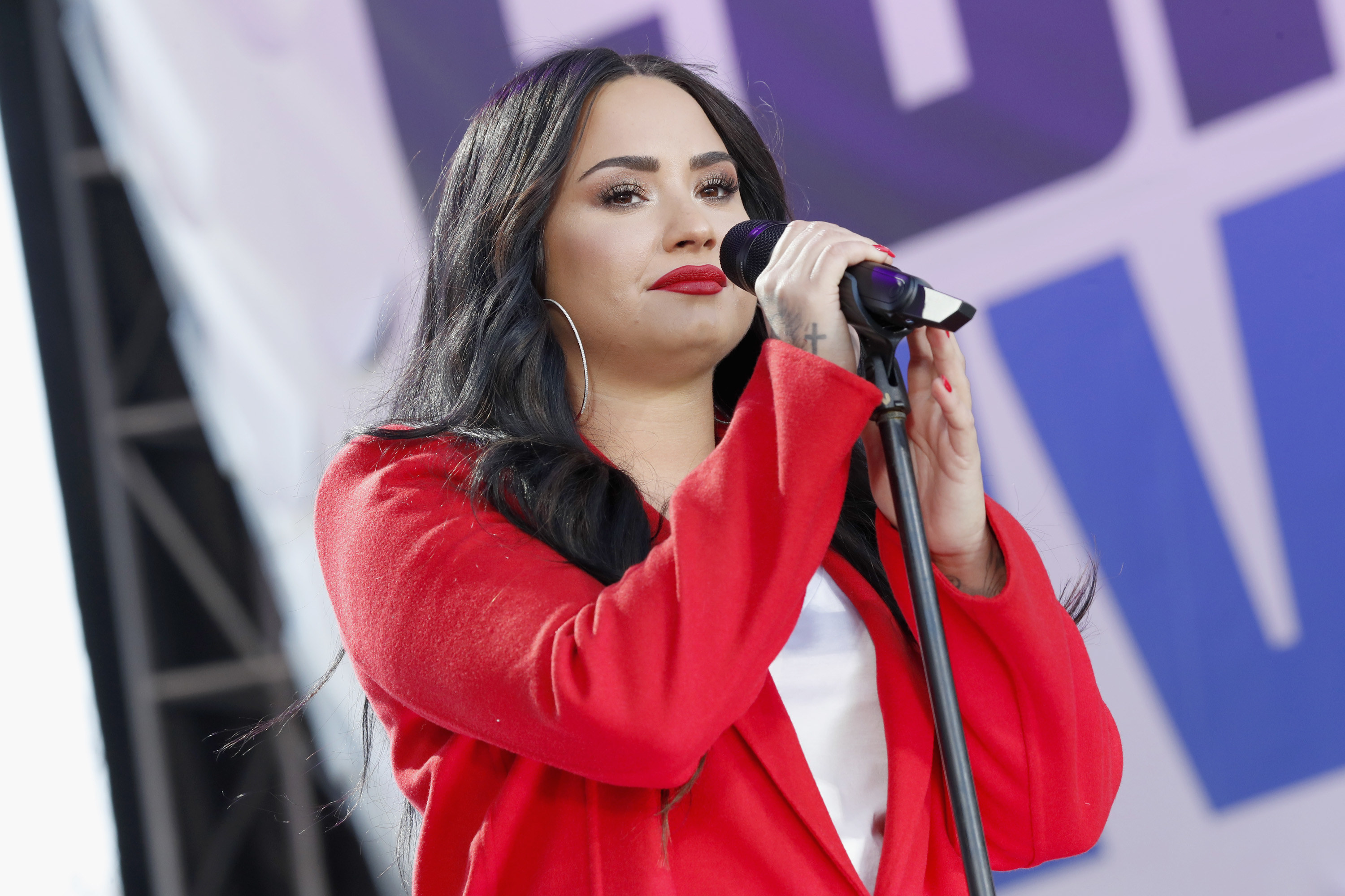 Demi Lovato holding a microphone on stage