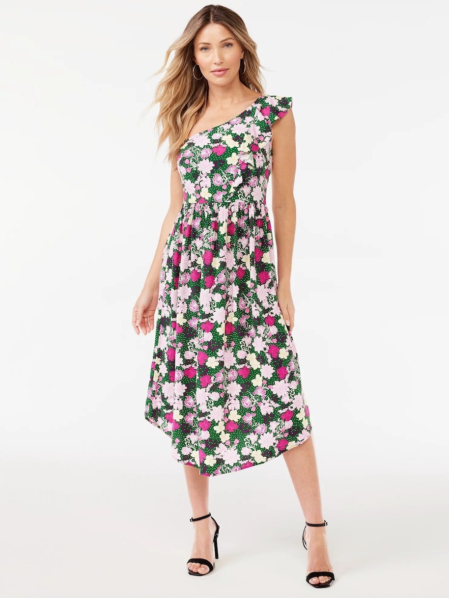 Model wearing long one-shoulder green, pink, and white floral dress