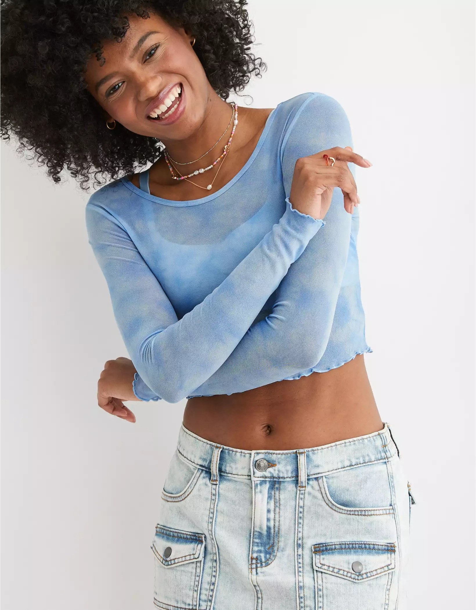 A model crossing their arms and smiling while wearing the lettuce trim top in blue