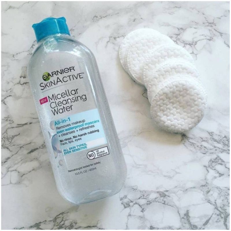 A bottle of micellar water with cotton rounds
