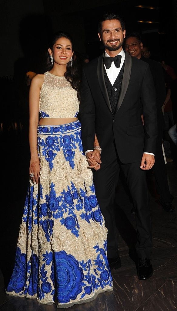 Indian Bollywood actor Shahid Kapoor (R) and his wife Mira Rajput arrive for their wedding reception in Mumbai