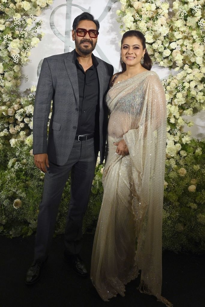 Bollywood actors Ajay Devgn (L) and his wife Kajol pose during the wedding reception party