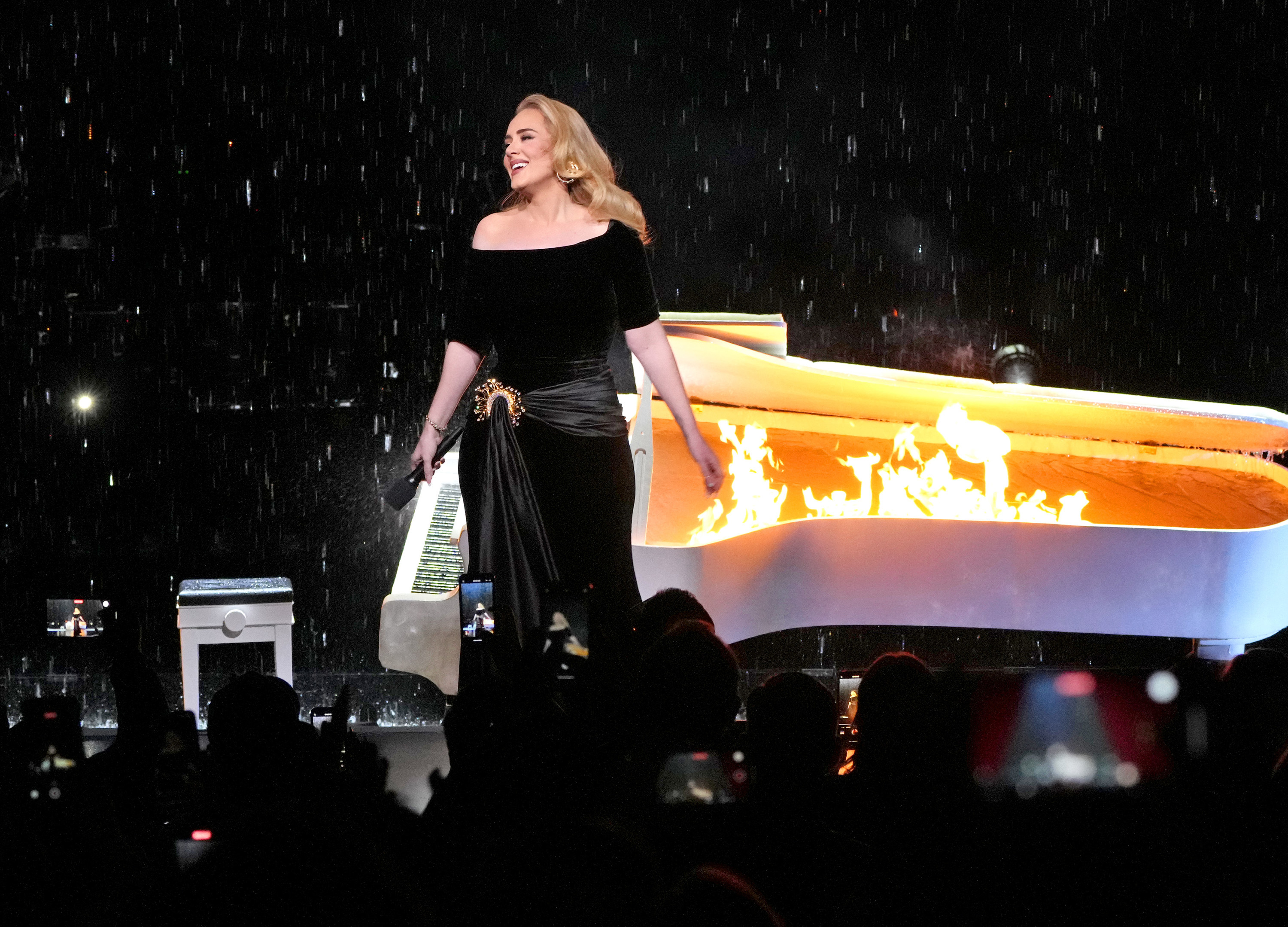 Adele in front of a flaming piano