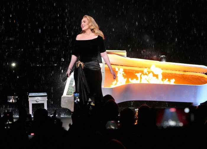 Adele in front of a flaming piano