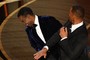 Will Smith (R) slaps US actor Chris Rock onstage during the 94th Oscars
