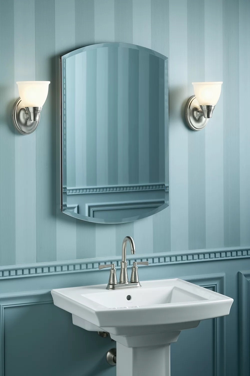 a bathroom vanity above a porcelain sink and against powered blue walls