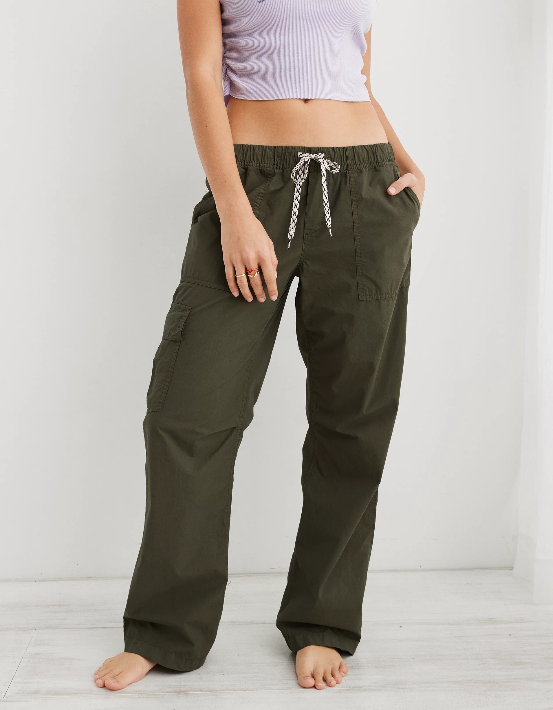 A model shot from the neck down wearing a crop top and the pants in olive