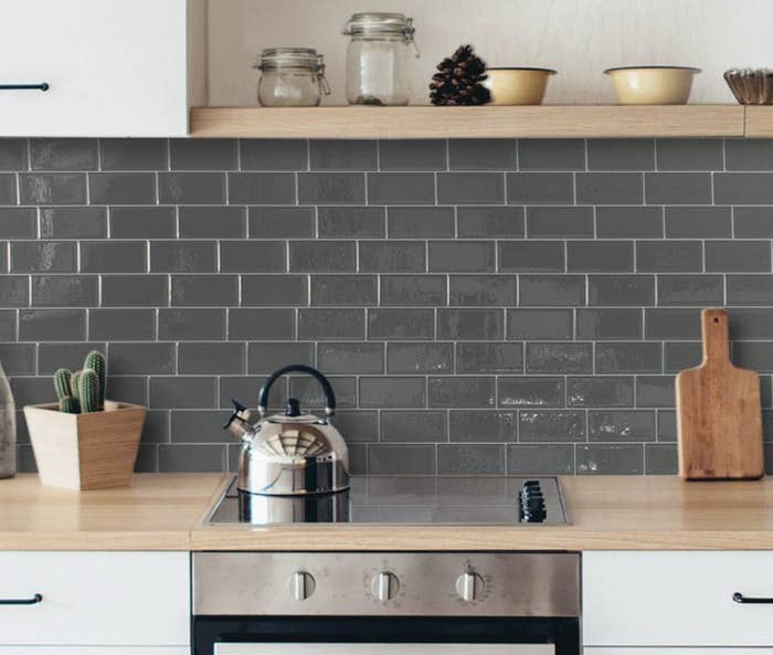 Grey backsplash tiles behind a stove