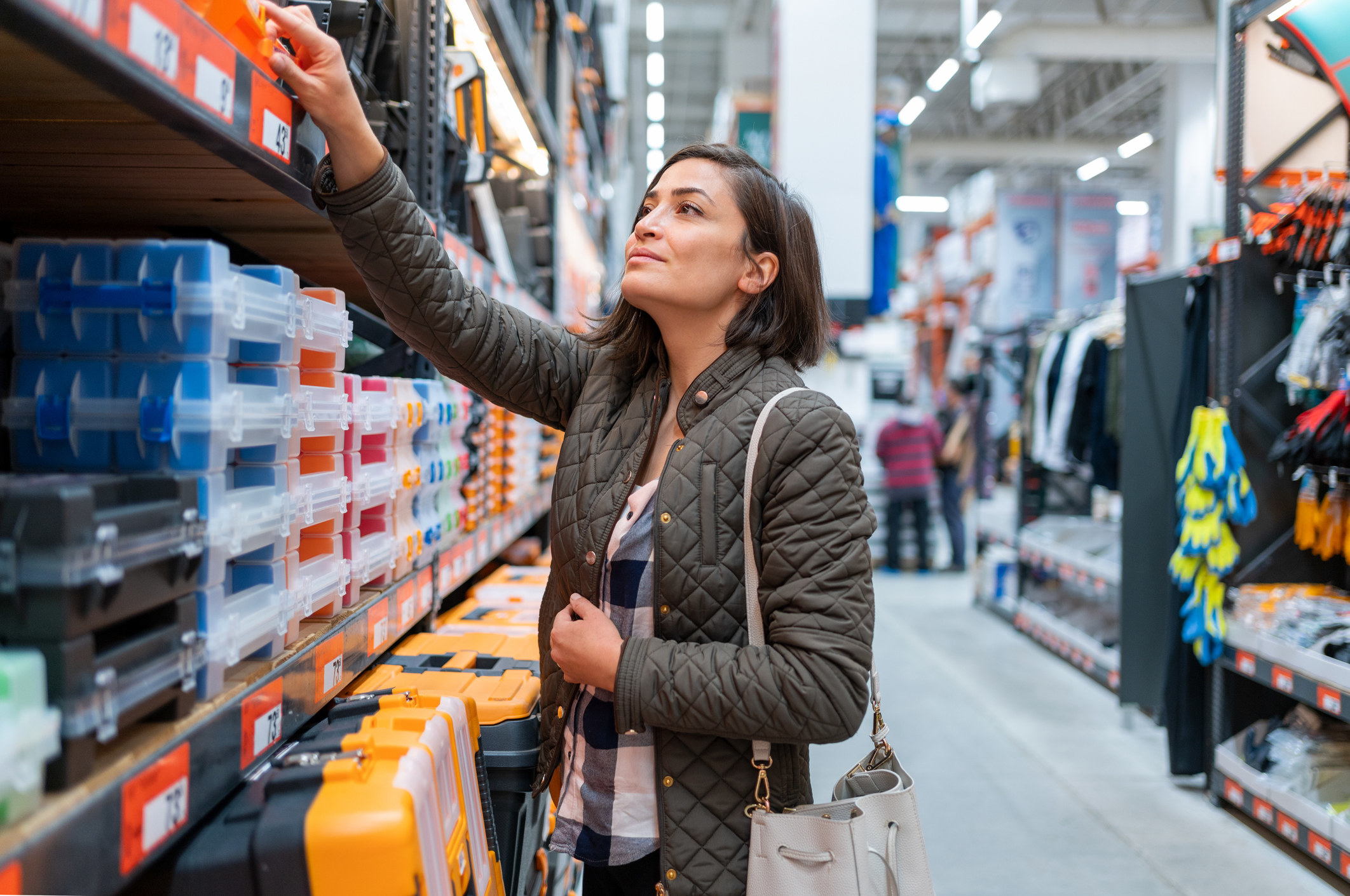 woman picking out an item in a store aisle