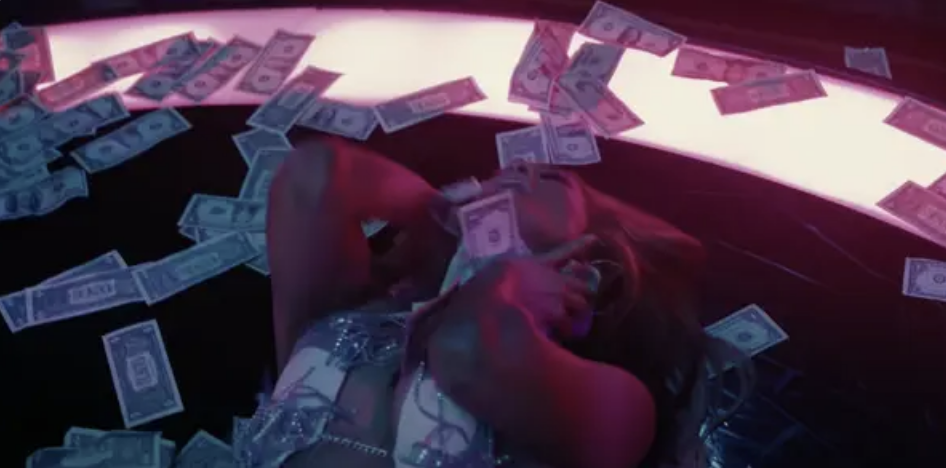 Jennifer Lopez lying on a pile of money in &quot;Hustlers&quot;