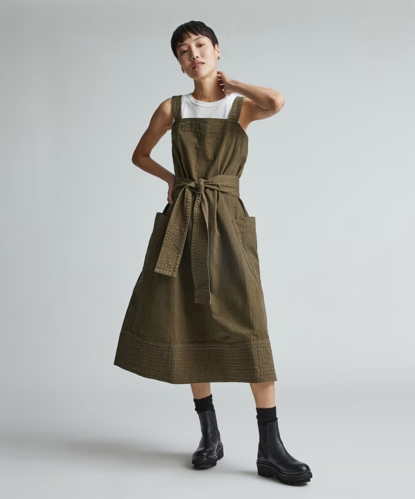 Model wearing green dress over white tee with black boots