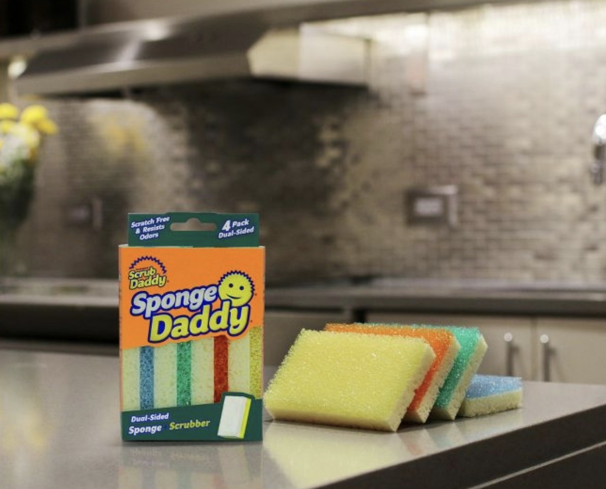 A box of sponge daddy sponges on a counter next to four sponges