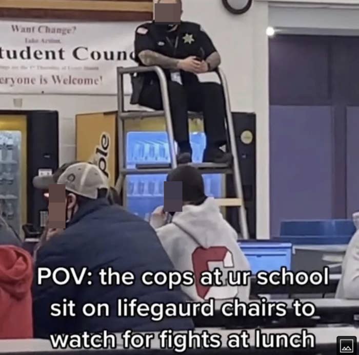 police sitting on a lifeguard chair watching over students