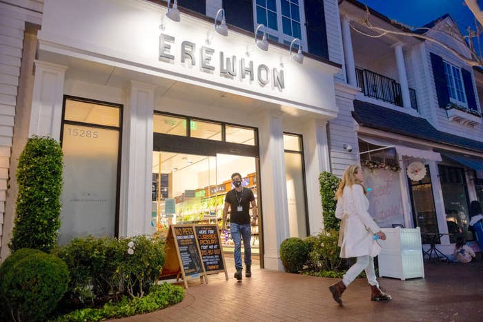 An employee wearing a mask walks out of an Erewhon store