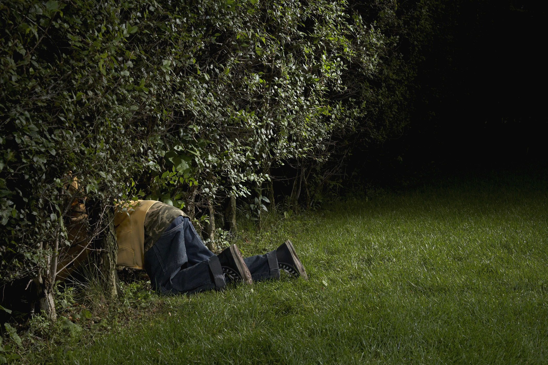 A boy crawling in bushes
