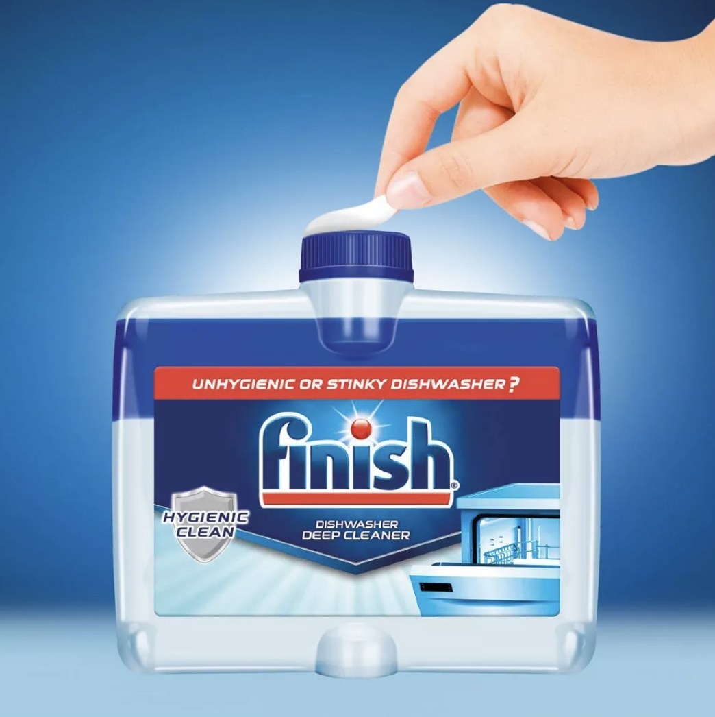 A hand opening a container of dishwasher cleaner