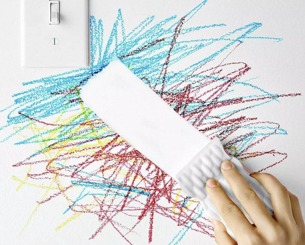 A white sponge wiping away crayon