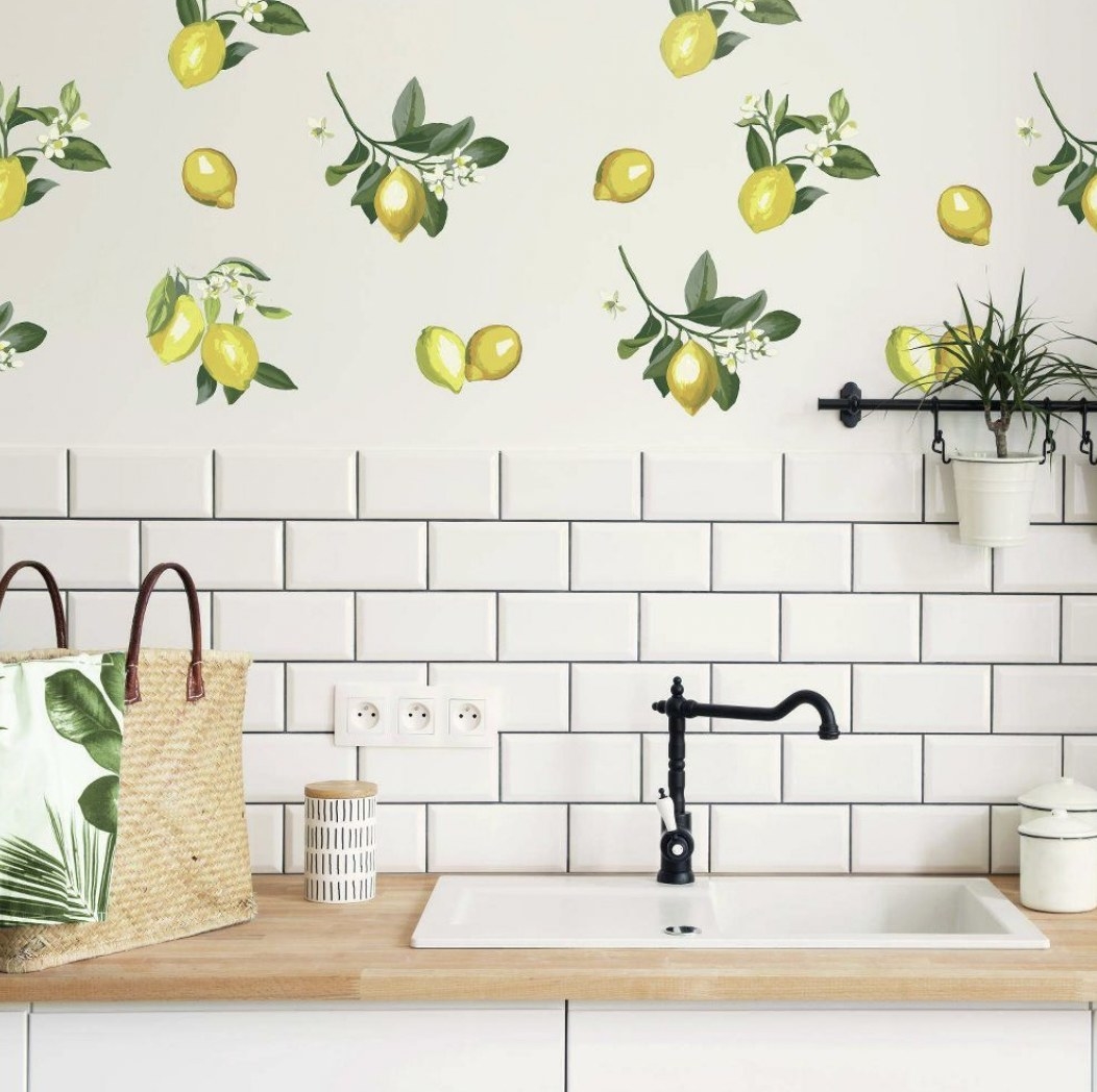 A white wall covered in lemon decals behind a sink