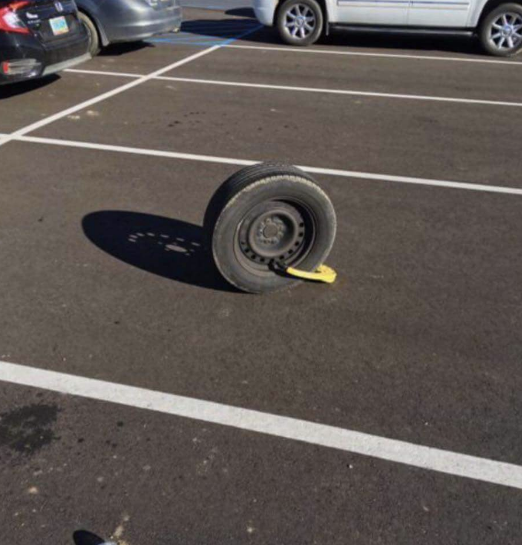 A single tire with a lock in a parking space