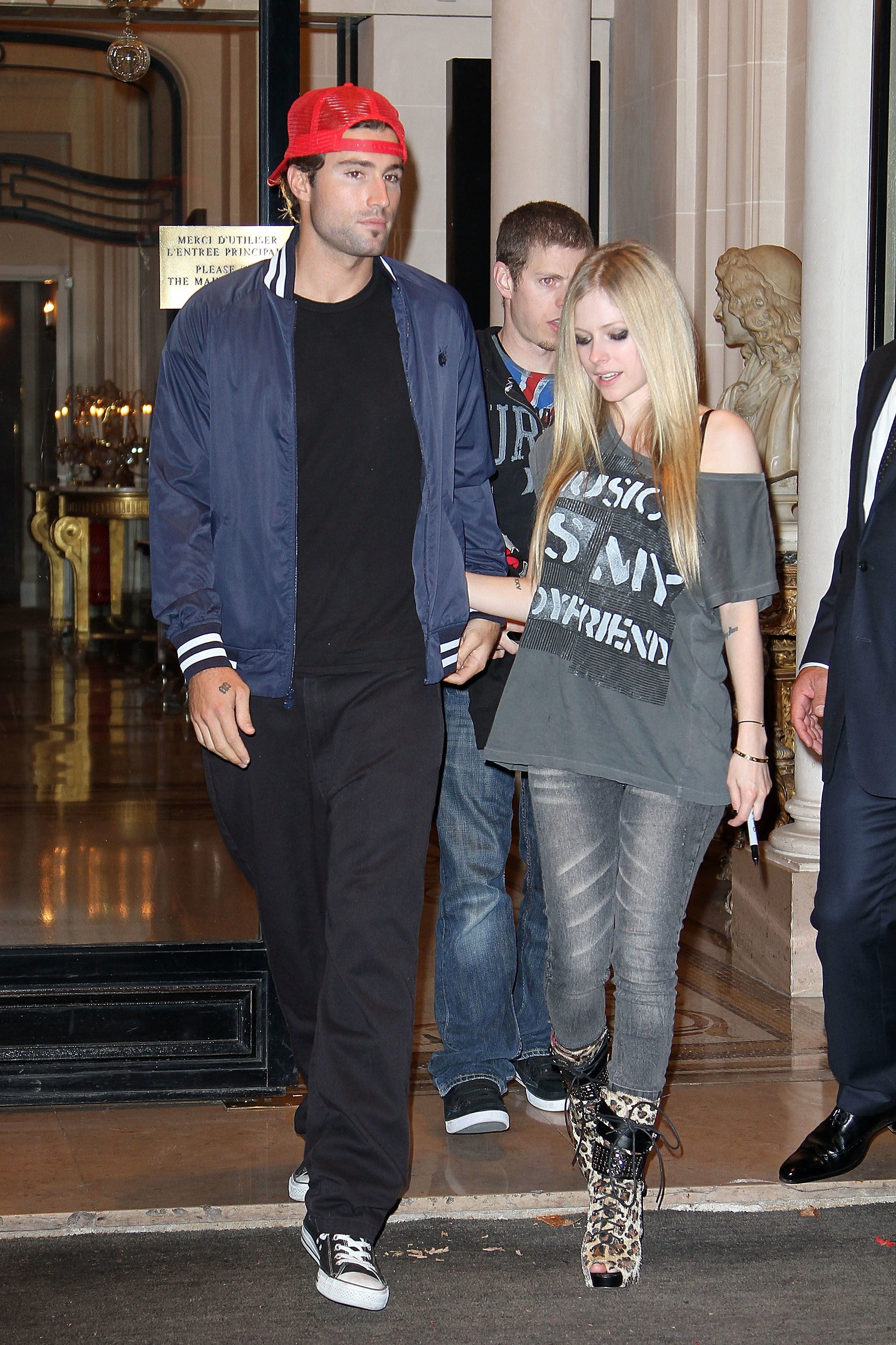 Avril walking out of a building with Brody Jenner