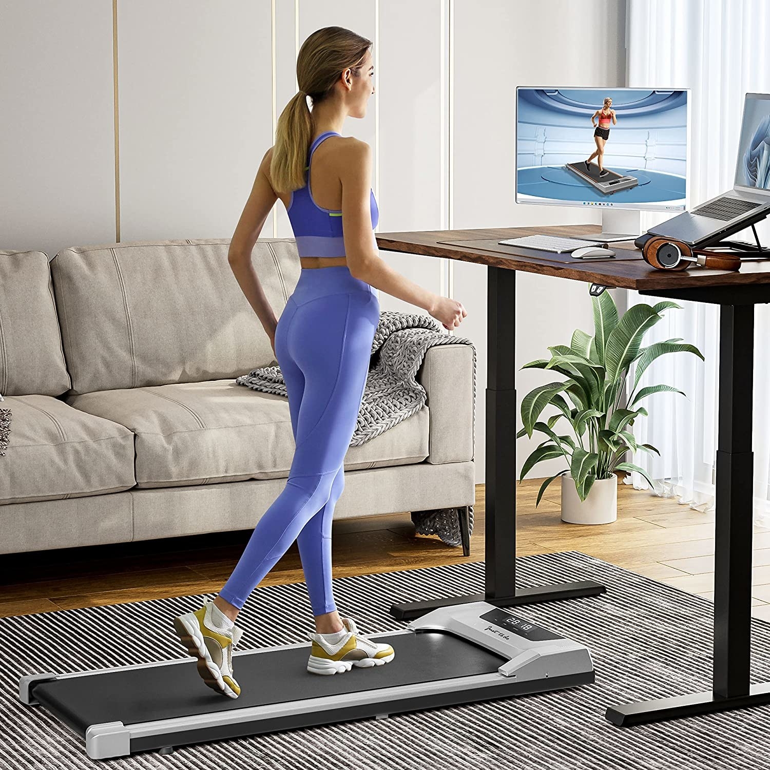 person walking on the treadmill while working at the standing desk
