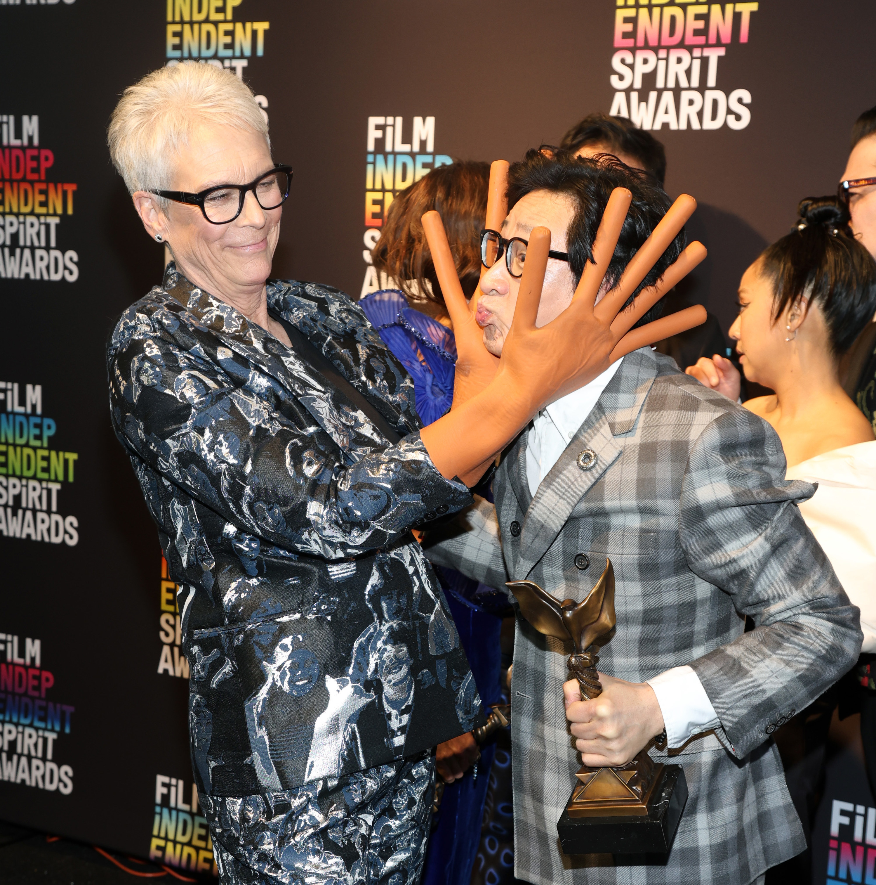 Jamie, with hot dog fingers, messing with fellow cast member Ke Huy Quan on the red carpet