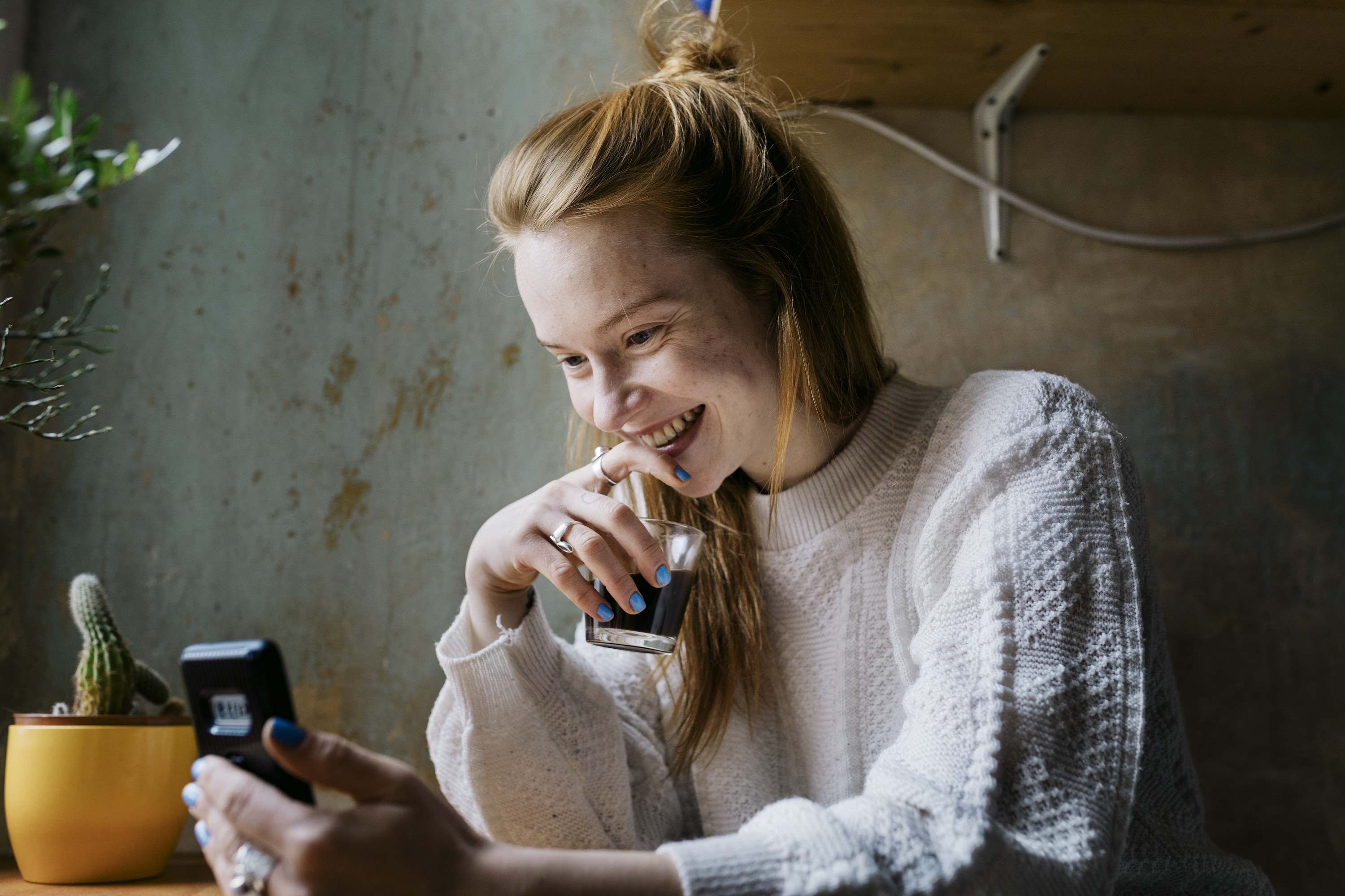 A woman smiling while on her phone