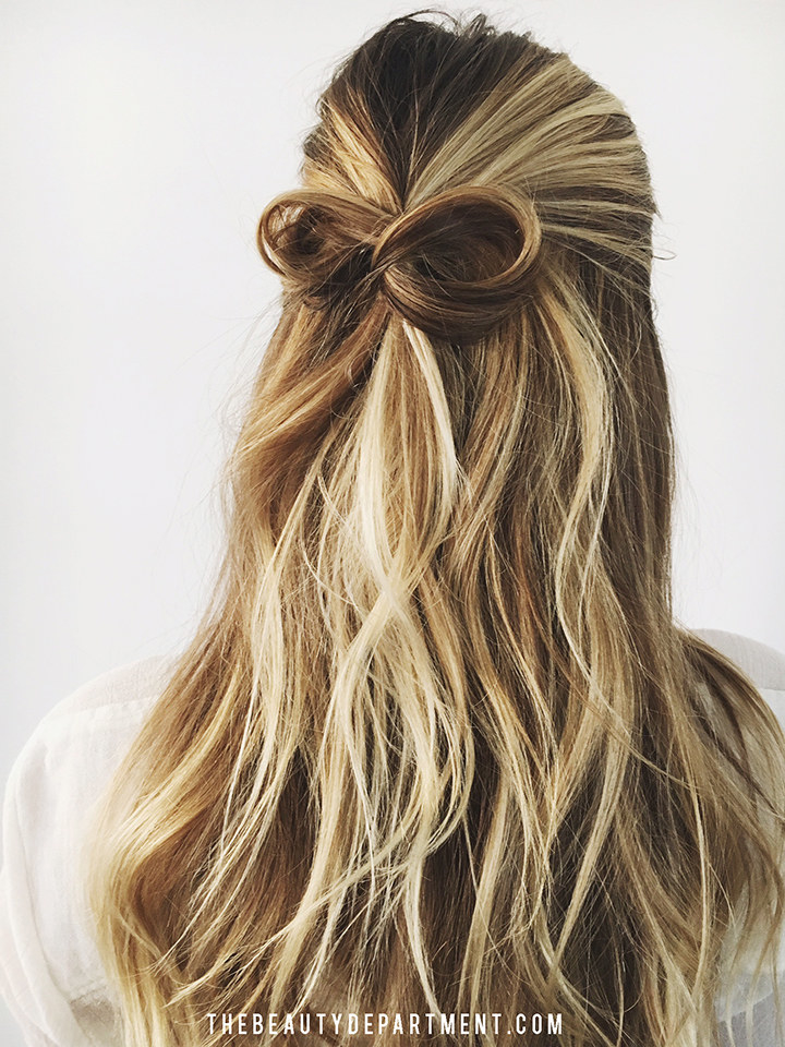 blonde hair styled half-up tied in a bow