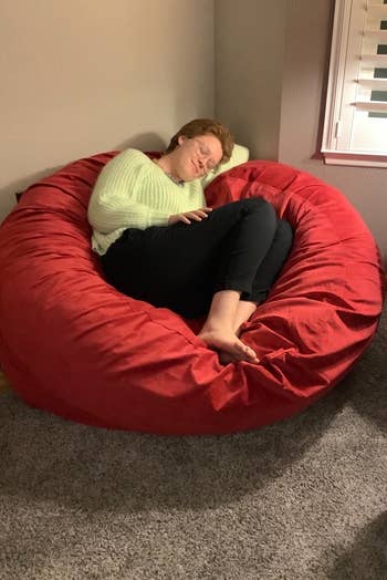 a reviewer lying in the red bean bag chair
