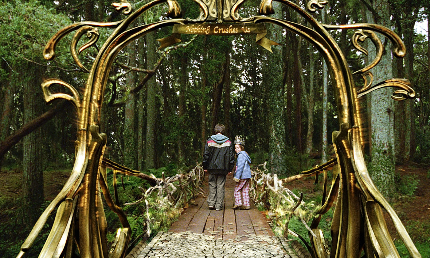 A young boy and girl walk across a bridge