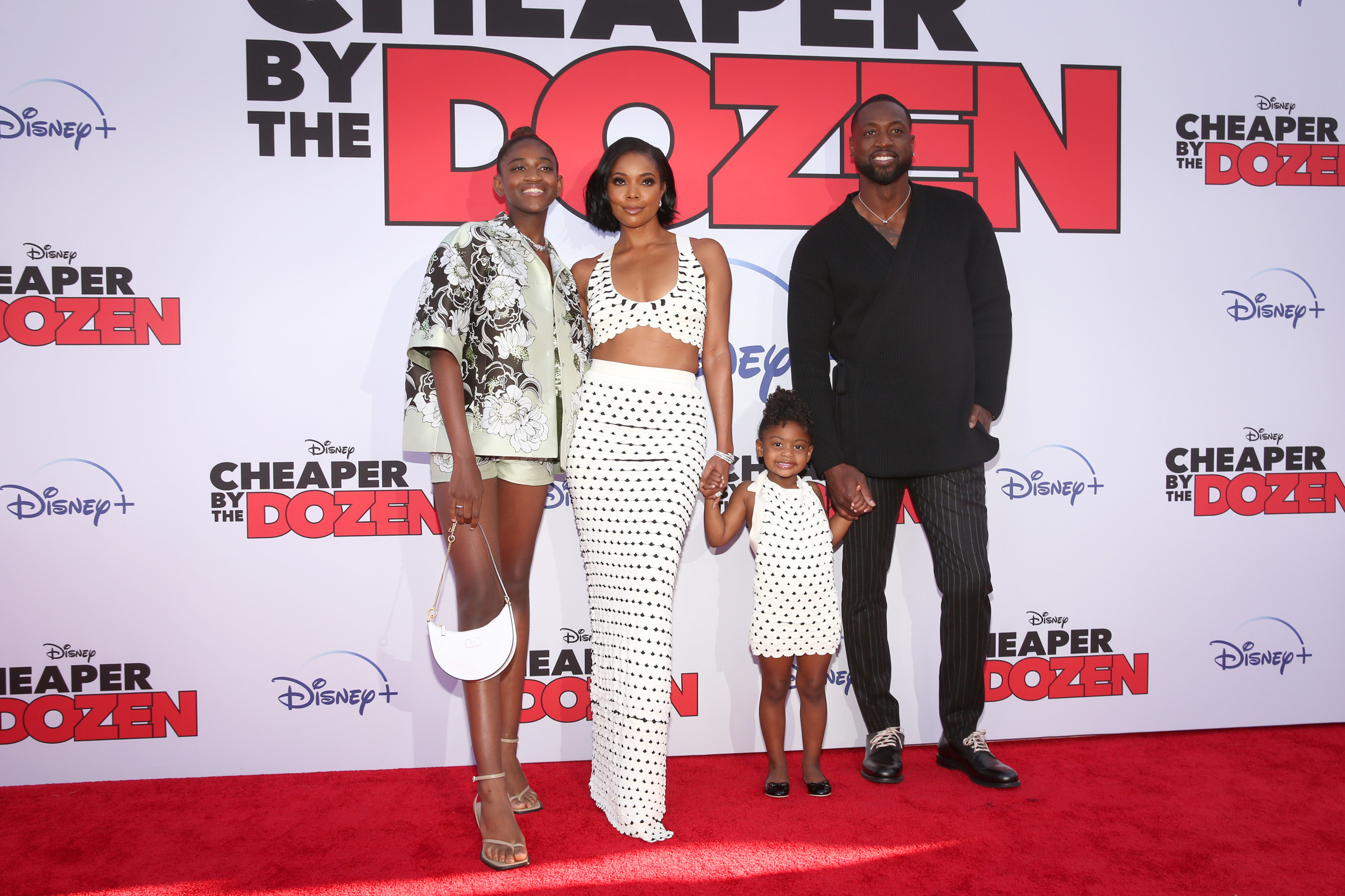 Zaya poses on a red carpet with Gabrielle, Dwyane, and her little sister