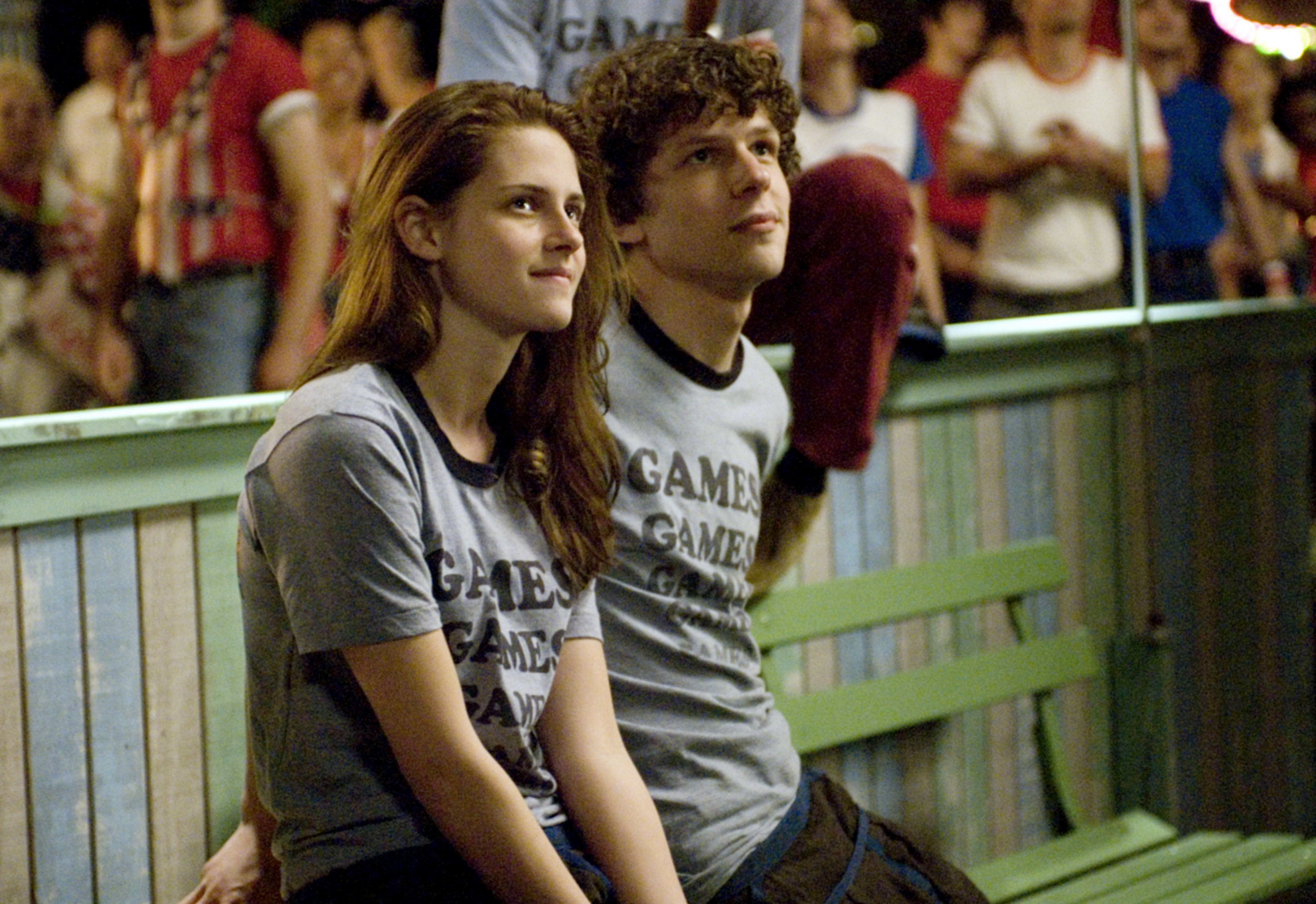 A teenage boy and girl sit at a carnival