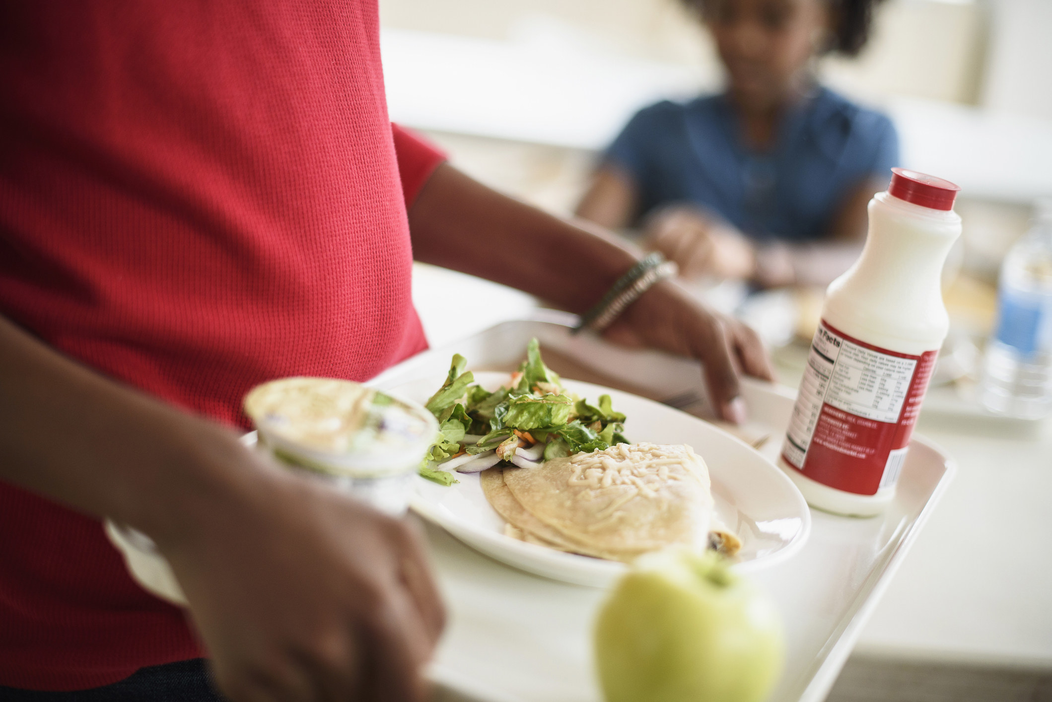 A student holding a school lunch tray