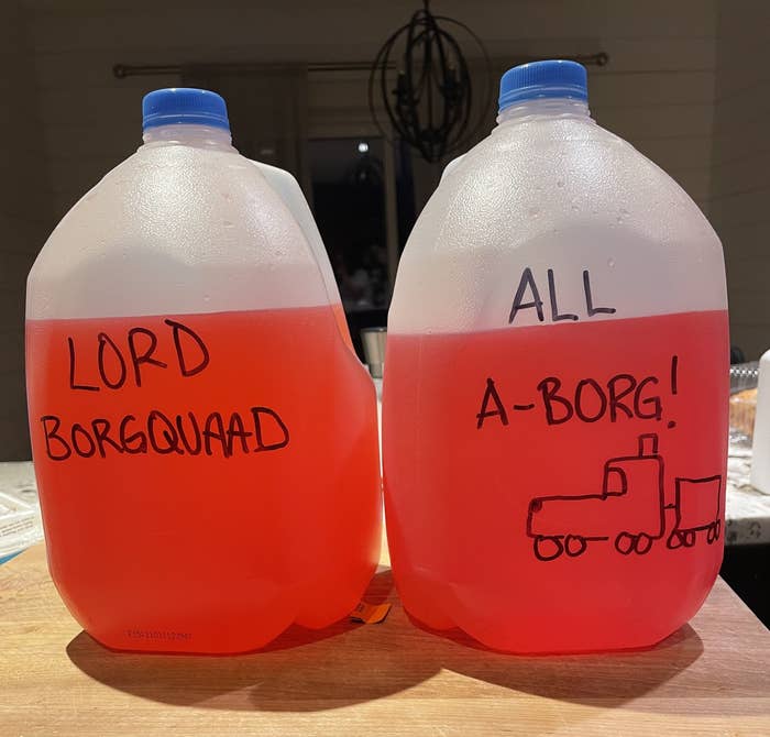 Two gallon water jugs filled with red liquid; one is labeled "Lord Borgquaad" and the other says "All A-borg!"