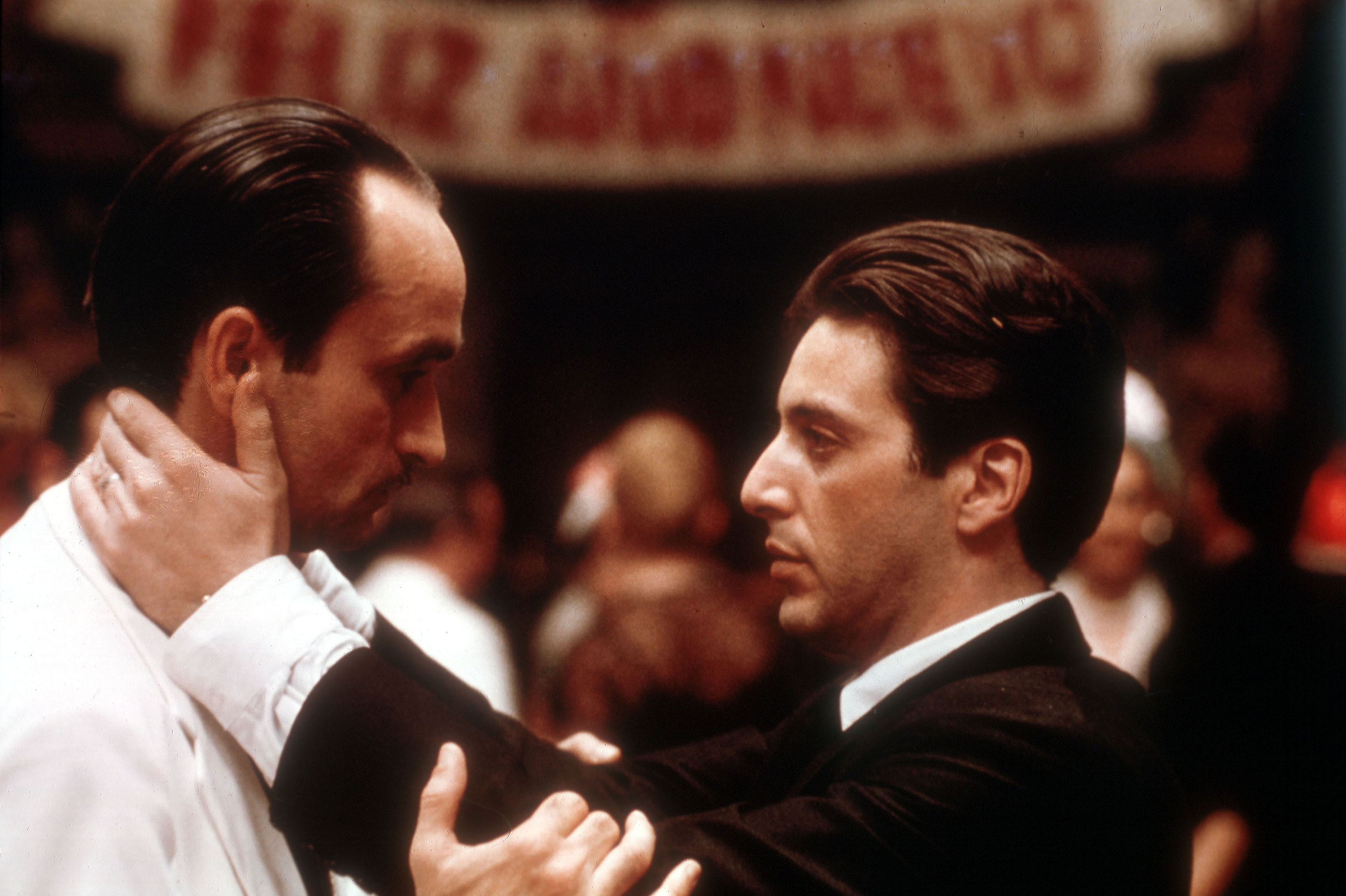 Al Pacino as Michael holds John Cazale as Fredo by the neck at a crowded upscale party
