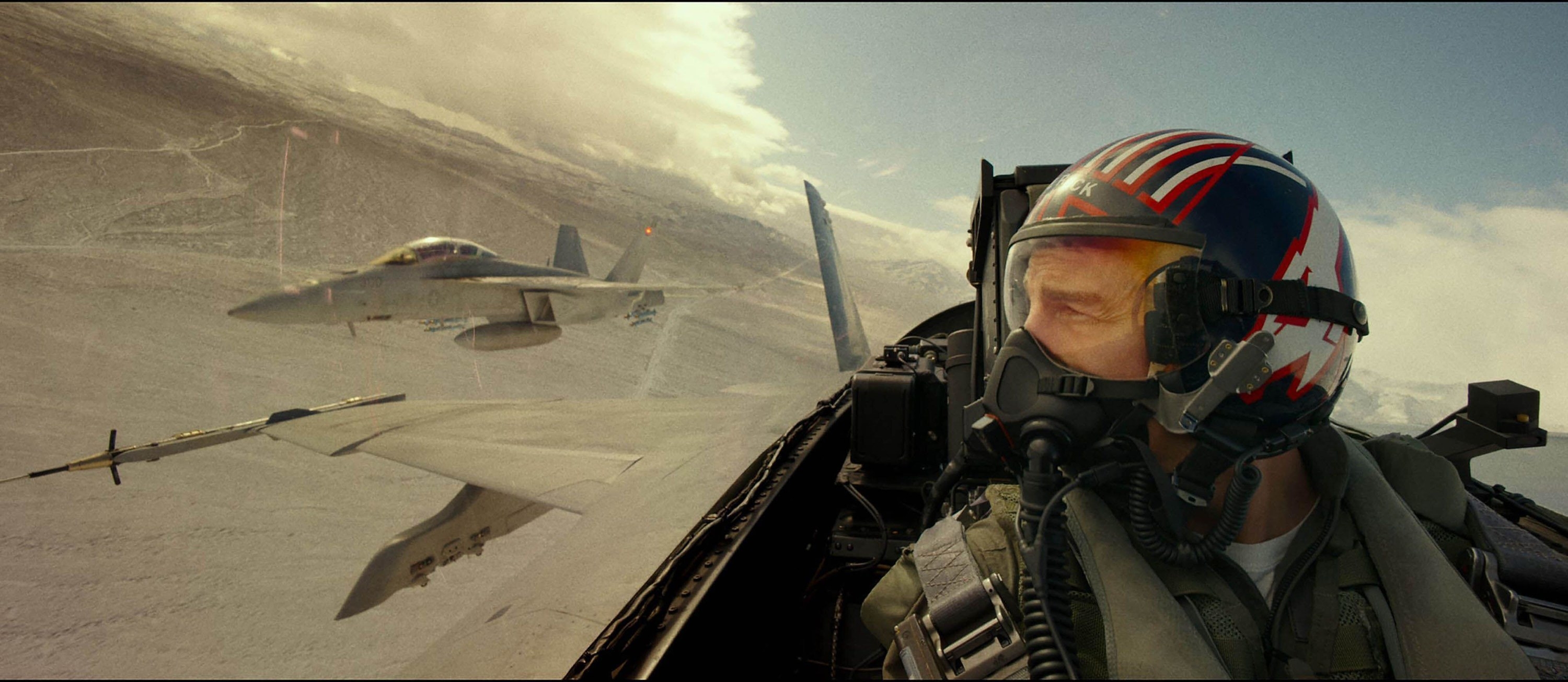 A jet pilot looks over to a pursuing jet on his right side