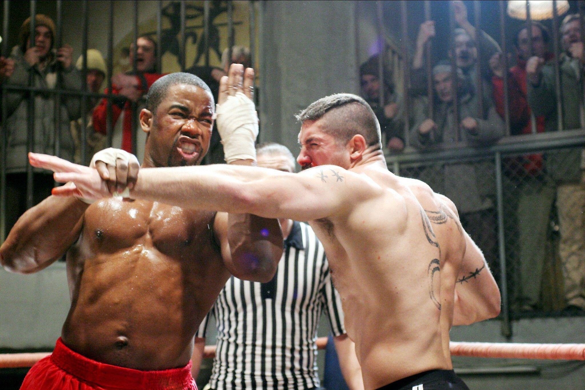 Michael Jai White and Scott Adkins engage in a mixed martial arts fight in prison