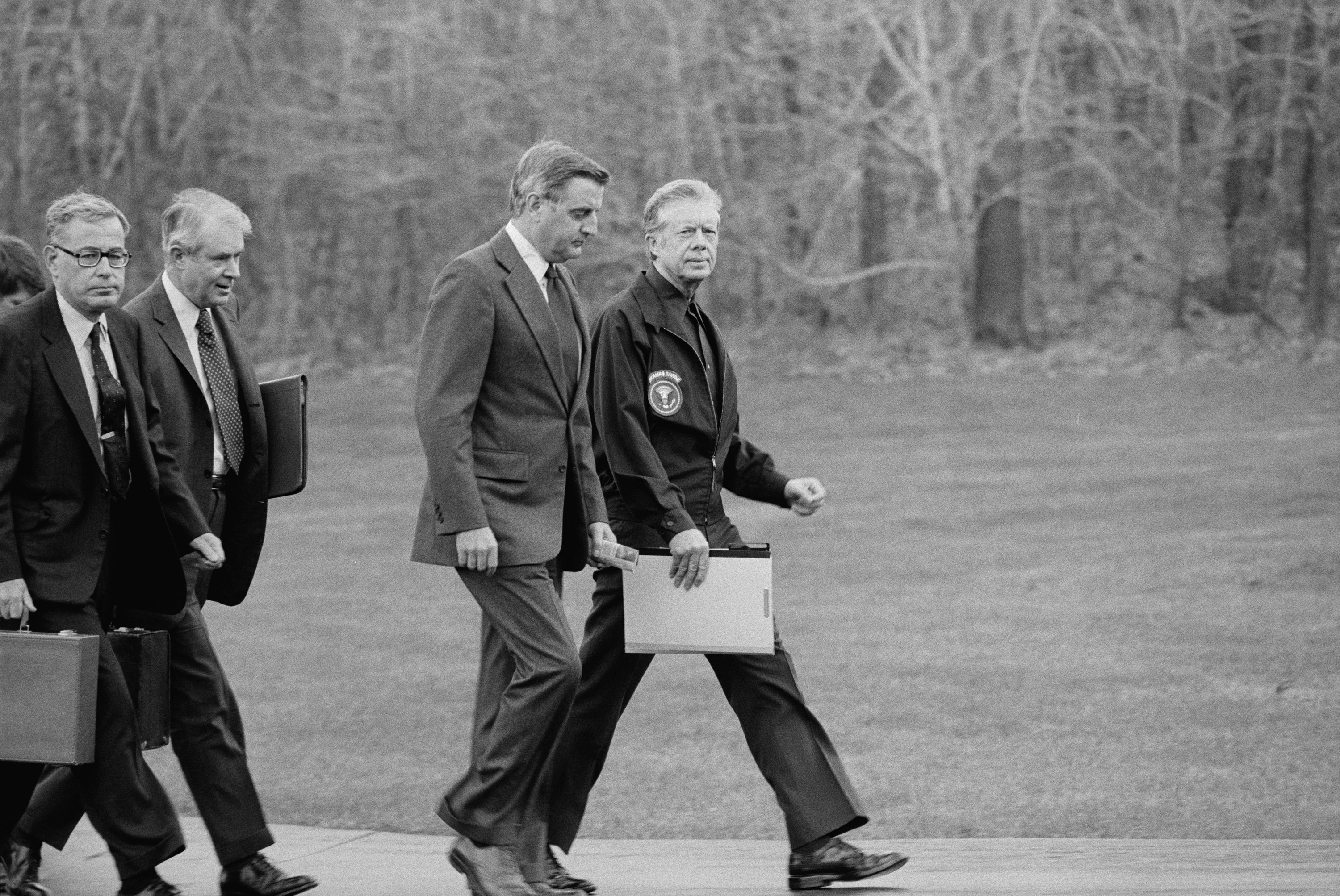 President Jimmy Carter, Vice President Walter Mondale, Secretary of State Cyrus Vance, and Secretary of Defense Harold Brown after disembarking from their helicopter to meet about Iran hostage crisis